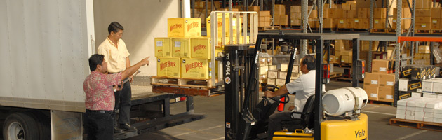 forklift operator loading boxes into truck inside FTZ warehouse